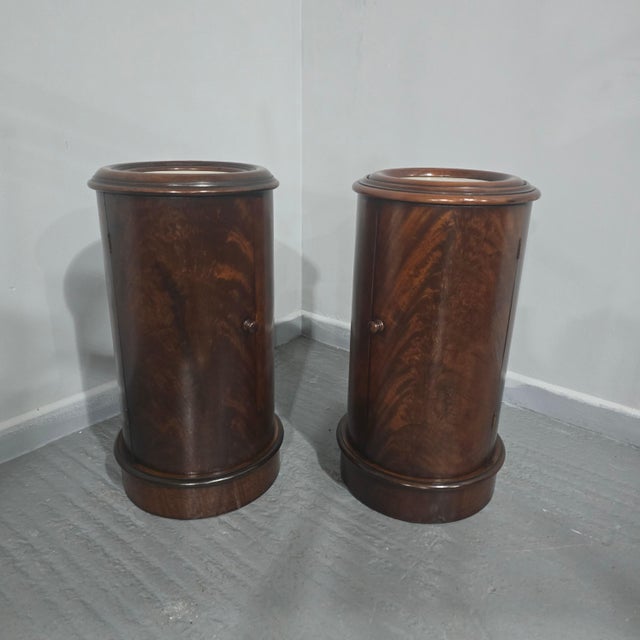 Fine pair of cylindrical mahogany bedside lamp cabinets, single door with inset white marble top, in excellent overall...
