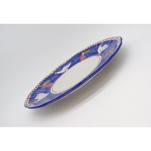 In the style of Solimene Vietri, this blue and white plate features rustic/folk art images of roosters and pears in shades...