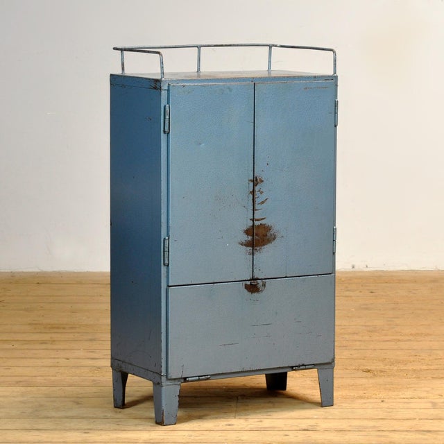 Bring a touch of vintage industry to your interior with this robust 1970s cabinet. Made of iron and finished in a blue hue...