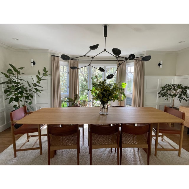 A pair of authentic Glass Up Down wall sconces by In Common With, featuring black steel hardware and hand-crafted...