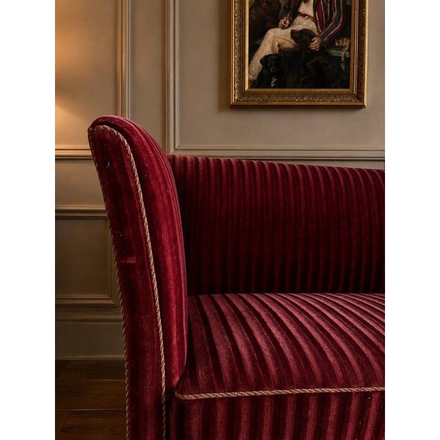 A beautiful Danish loveseat in the Henningsen style, Denmark, circa 1960s. Upholstered in rich deep burgundy mohair with...