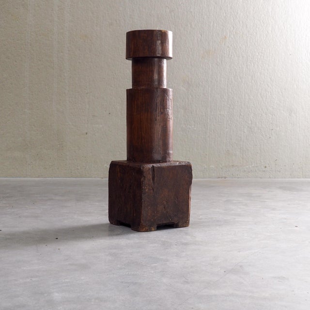 Carved from solid hardwood, this rustic sculptural piece features a bold, geometric silhouette with a deep, warm patina....