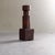 Carved from solid hardwood, this rustic sculptural piece features a bold, geometric silhouette with a deep, warm patina....