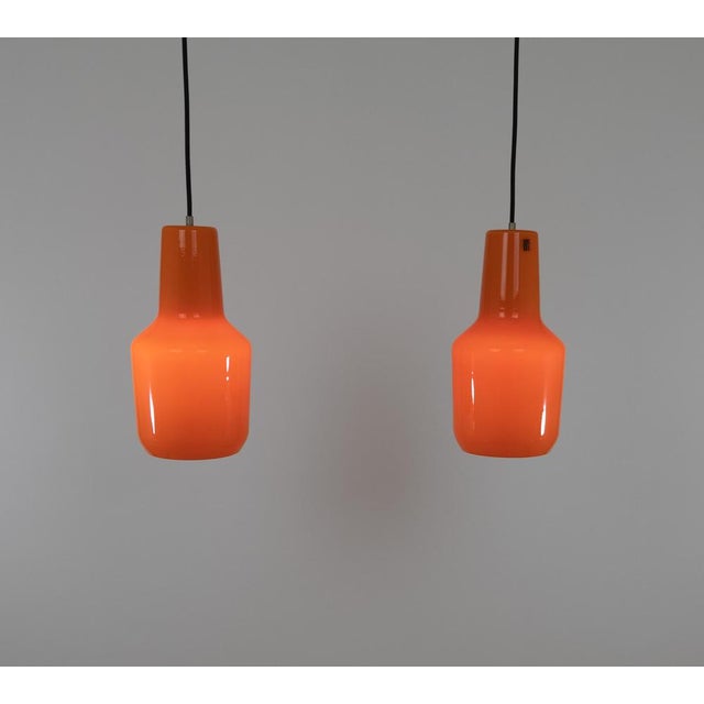 Pair of hand-blown glass orange pendants designed by Massimo Vignelli at the start of his impressive career in design and...
