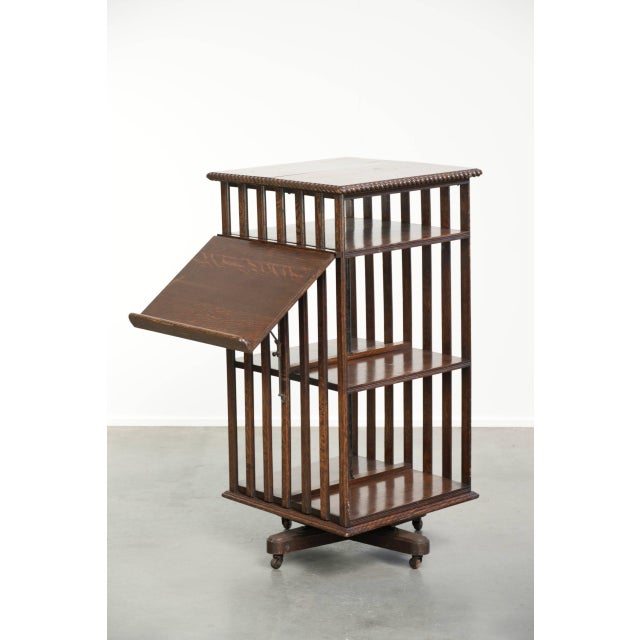 This unique antique English bookstand from the 19th century is made of oak and features a fold-down reading tray. The...
