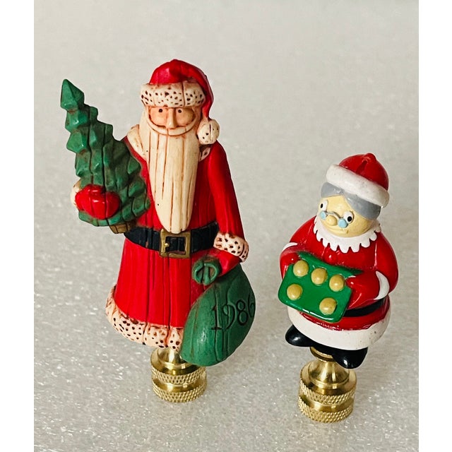 Vintage pair of Santa Claus and Mrs.Claus, 3” mounted on brass bases finials.