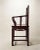 A striking pair of Chinese hardwood armchairs featuring tall open backs, shaped arms, pierced carved decoration, and...