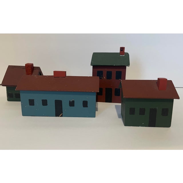 A set of four miniature folk art houses, two signed "Robbie 83" on the bottom. Largest: 2.75 H x 2 D x 4 W inches...