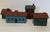 A set of four miniature folk art houses, two signed "Robbie 83" on the bottom. Largest: 2.75 H x 2 D x 4 W inches...