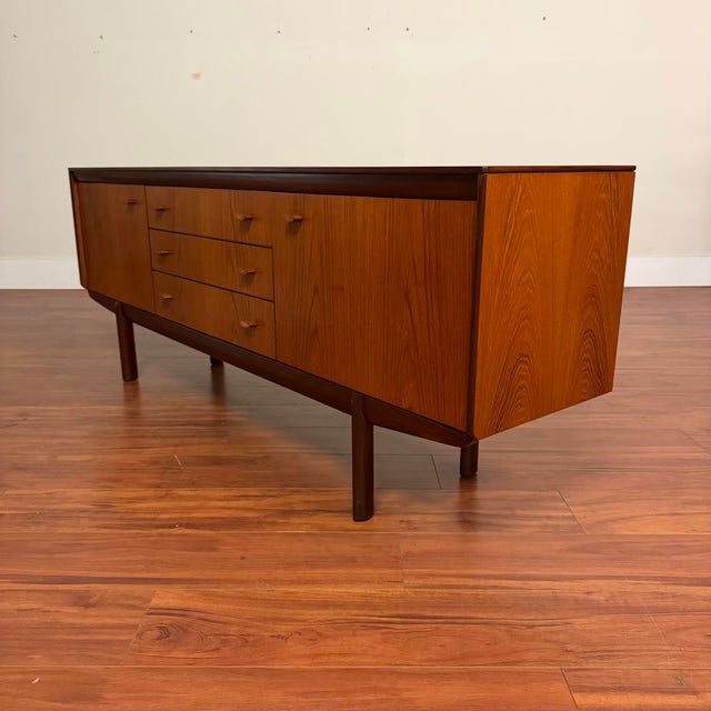 Vintage mid-century teak sideboard by White & Newton, made in the U.K. circa 1960's. This piece features beautifully book-...