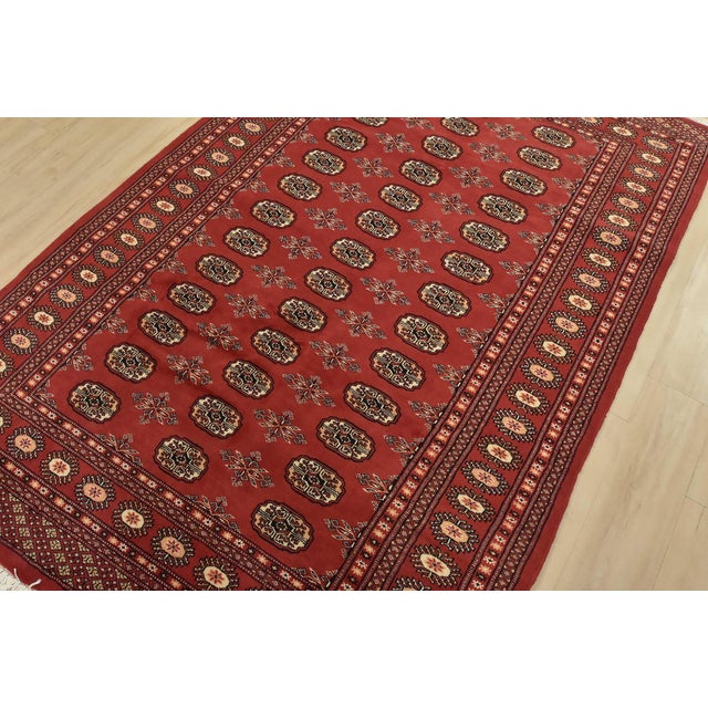 A tribal Bokhara rug hand-knotted with fine wool on a cotton foundation. This rug features rows of repeating medallions...