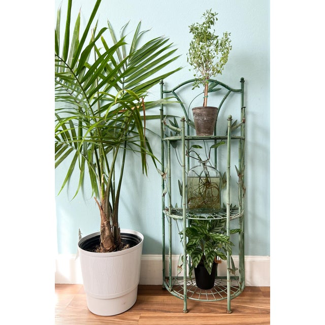 Charming vintage metal étagère featuring an elegant faux bamboo form with sculptural botanical accents throughout....