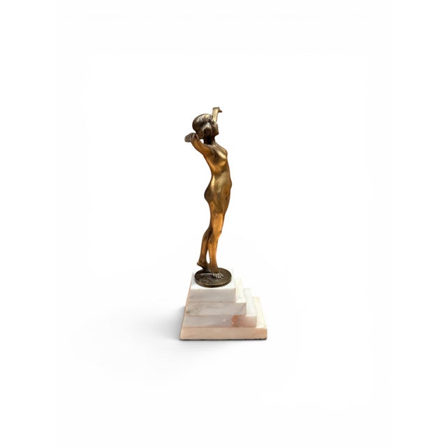 An elegant French bronze sculpture depicting a stylized nude female figure standing with arms gracefully outstretched in a...