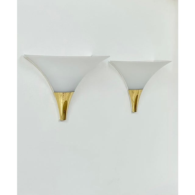 Pair of wall sconces produced by Limburg, featuring a patinated brass frame and an opaline glass diffuser, manufactured in...