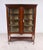 Elegant Edwardian mahogany display cabinet of refined proportions, featuring a pair of glazed doors with decorative...