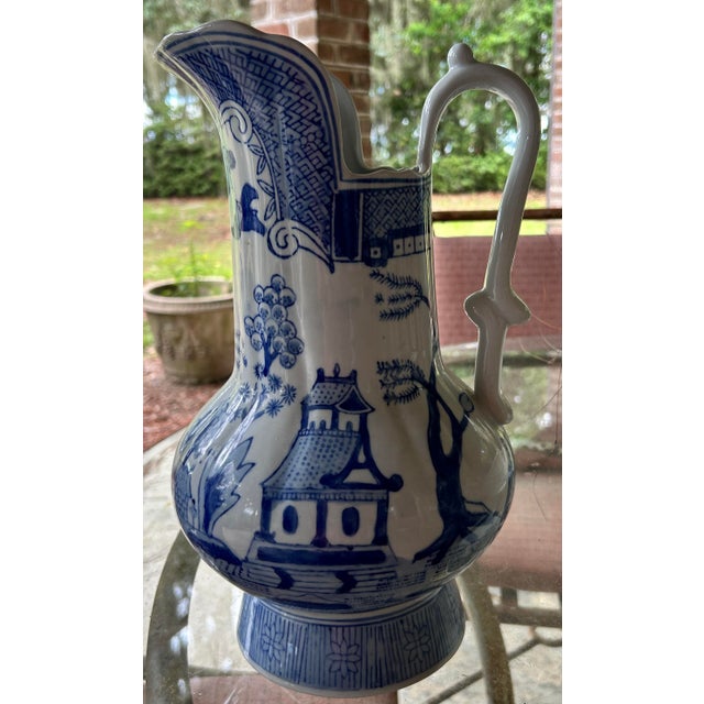 Striking large-scale Chinese blue and white porcelain pitcher or ewer featuring hand-painted traditional landscape scenes...
