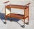 Beautiful vintage Mid-Century Modern rolling bar cart featuring warm teak wood shelves, elegant chrome accents, and...