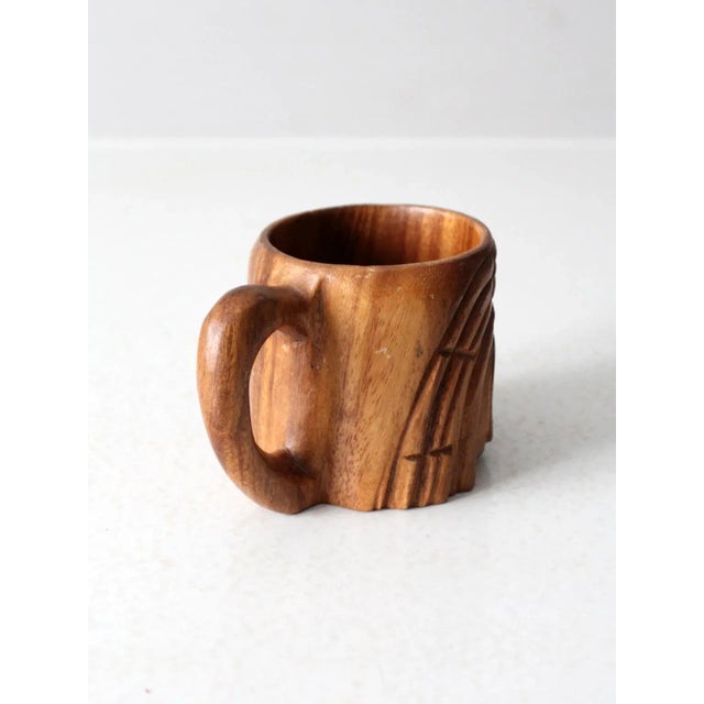 This vintage tiki mug is hand-carved from monkey pod wood, featuring bold facial features and textured detailing. The warm...