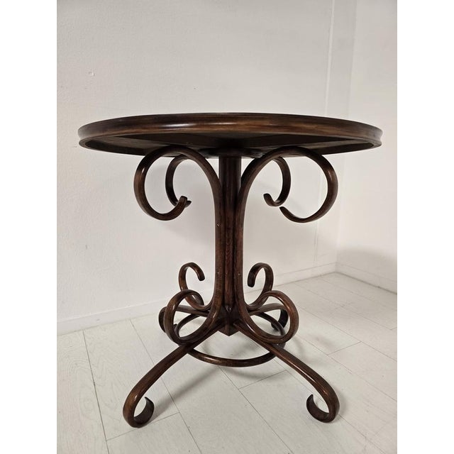 Elegant bentwood bistro table attributed to Thonet, Central Europe, mid-20th century. The table features a sculptural...