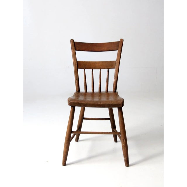 An antique farmhouse chair with understated primitive character and beautifully aged wood. The dining or side chair...