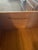Vintage American of Martinsville dresser is constructed from dark-stained wood with a black laminate or leather-look top....