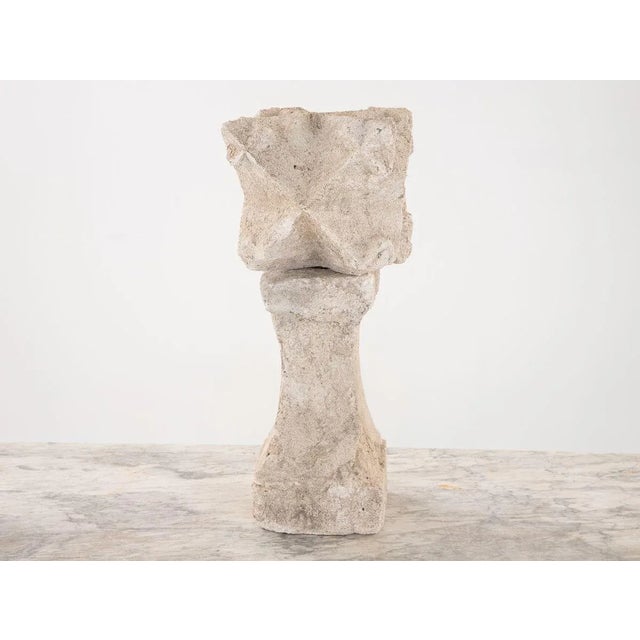 A carved stone reclaimed architectual element of a geometric shape on a stone plinth. Late 19th century. Wear consistent...