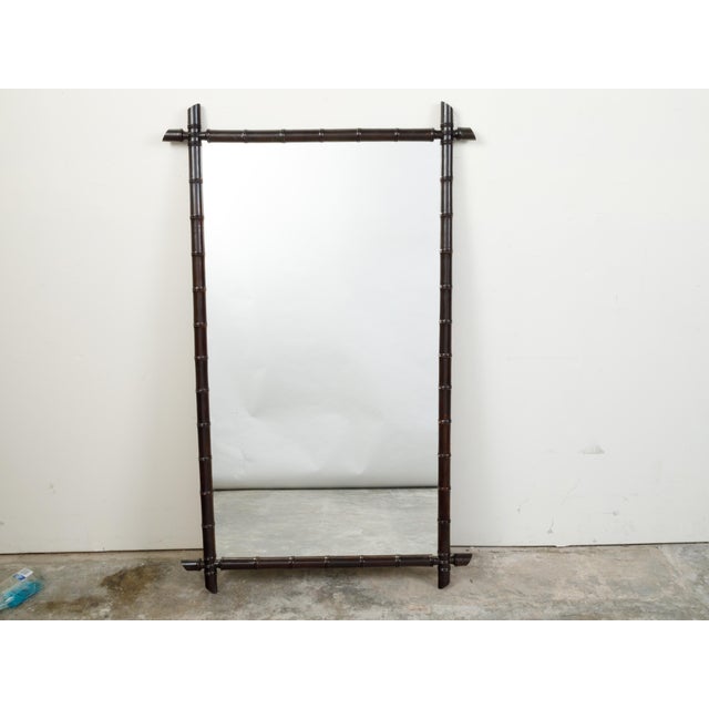 A French rectangular faux-bamboo mirror from the early 20th century, with black patina. Created in France during the Turn...