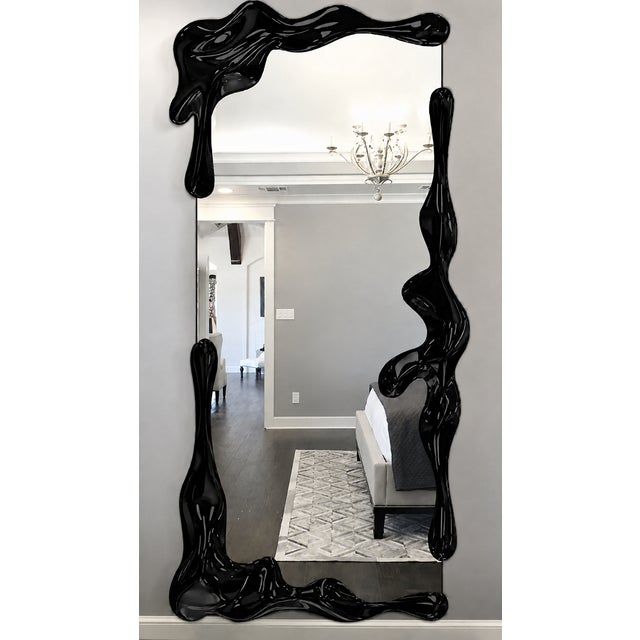 A striking fusion of functional design and contemporary sculpture, this oversized full-length mirror features a dramatic,...