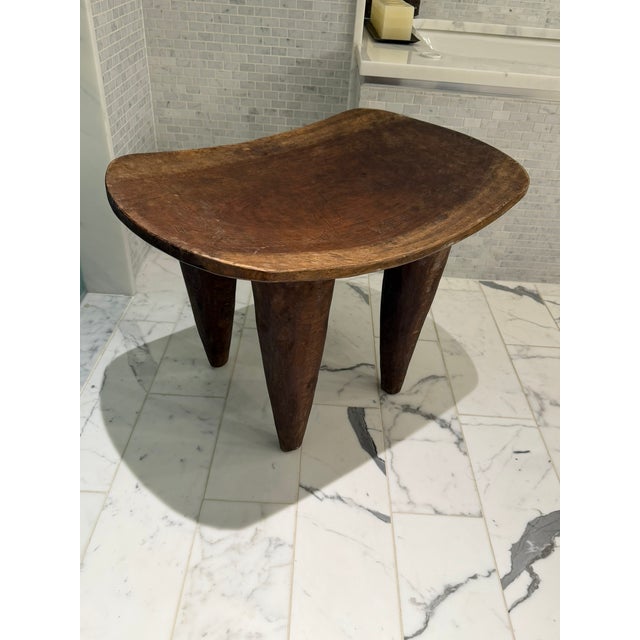 A beautifully hand‑carved wooden stool sourced from Material Possessions in Chicagoland, known for their curated mix of...
