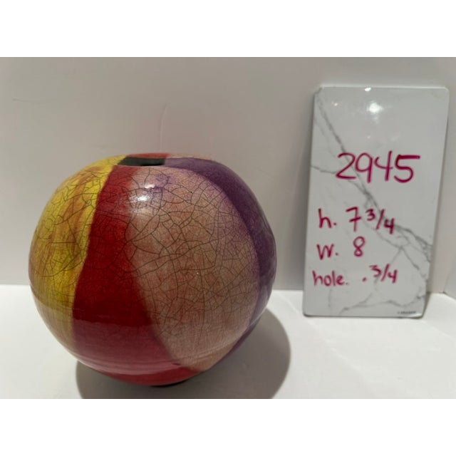 Raku pottery vase identified by the owner as Peter Aslan. Rounded orb form with a narrow opening and bold yellow, red,...