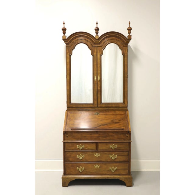A Georgian style secretary desk by Baker Furniture. Walnut with brass hardware, double bonnet arched top with three...