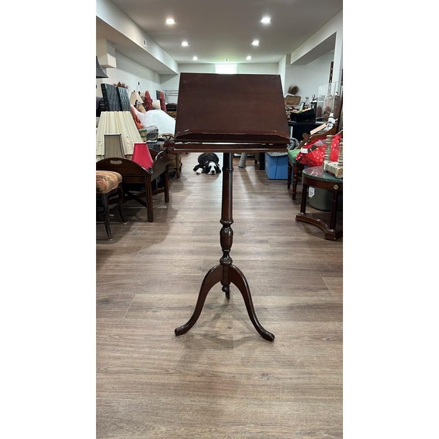 This vintage mahogany-finish wood pedestal stand functions as both an adjustable lectern music stand and a compact side...