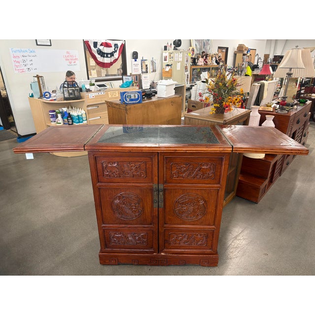 This Chinese bar cabinet features a pair of doors that open to reveal a beautiful setup of storage compartments for drinks...