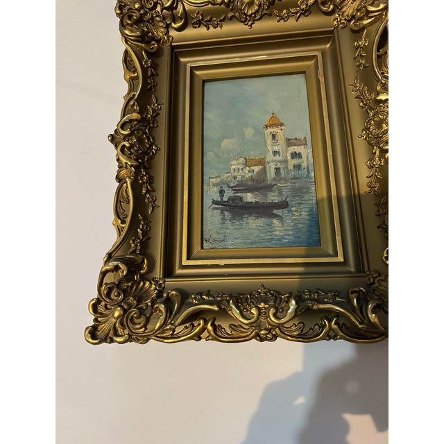 Antique Venetian canal scene oil painting. The artwork is housed in an ornate, gilt-carved frame typical of late 19th-...