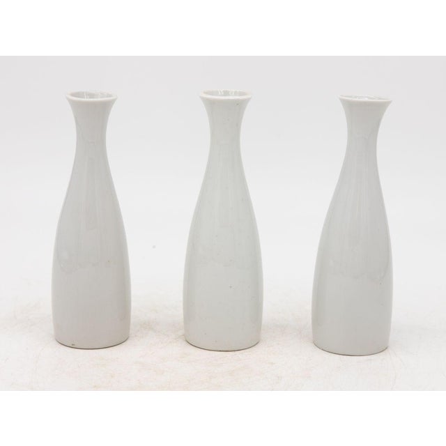 Each single white ceramic vase, crafted in early 21st century France, is part of a set of three, with multiple sets...