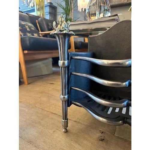 A turn of the 20th century circa 1900 English Brass, steel and cast iron fire grate/basket. The tapering front torchiere...