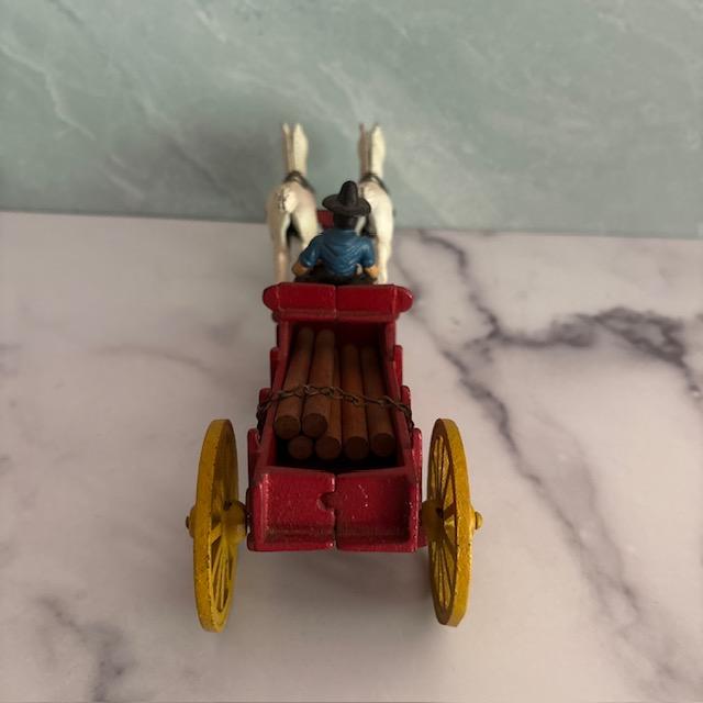 Early 20th-century figurine of Amish farmer and his horse team pulling a wagon of logs. Made of cast iron and hand-...