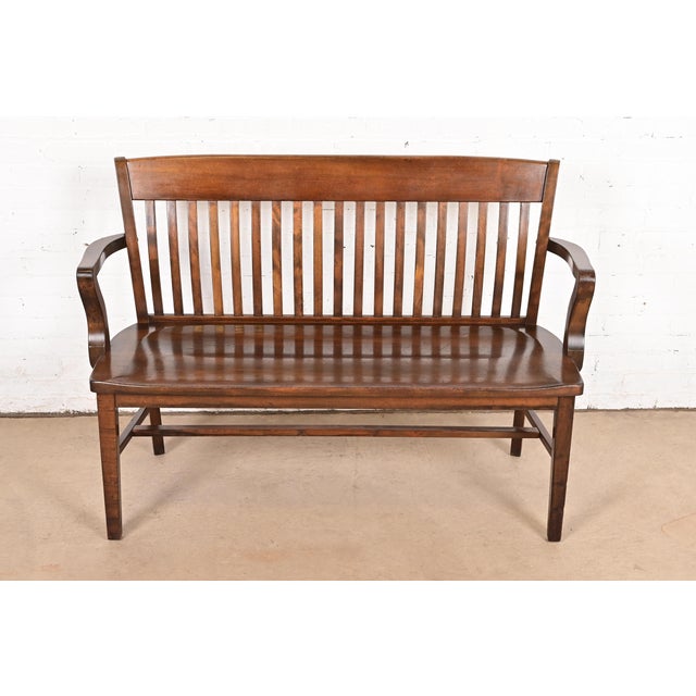An exceptional antique Arts & Crafts solid walnut spindle back banker or lawyer bench USA, Circa 1920s Measures: 52"W x...