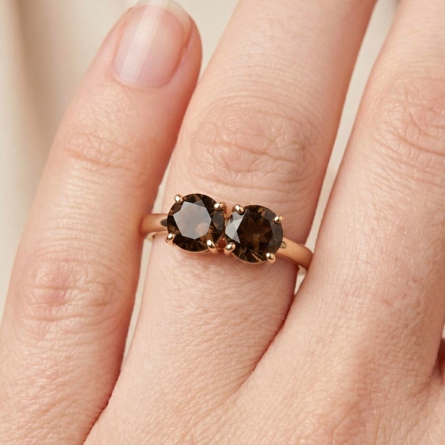Exude a grounded, sophisticated elegance with this captivating 18k gold-plated two-stone ring. Featuring a pair of...