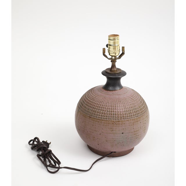 Artist signed stoneware pottery table lamp, 20th century. Spherical pottery lamp base with cut-in design to the clay, in a...
