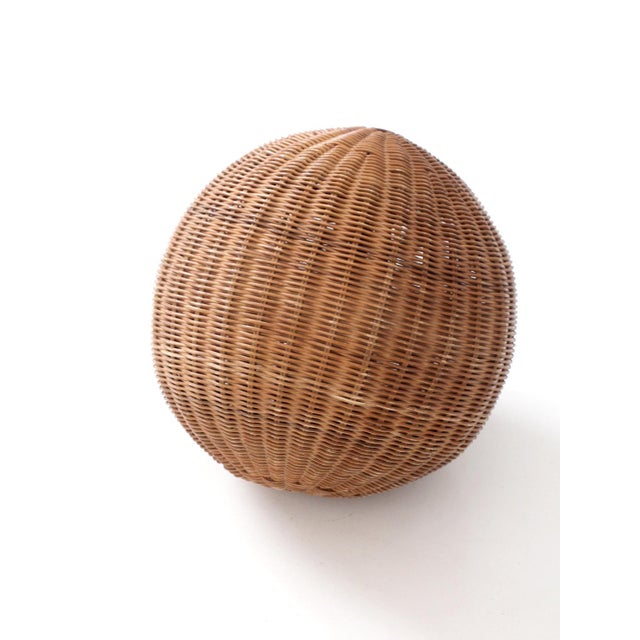 A large vintage wicker orb with a tightly woven spiral form and sculptural rounded silhouette. The ribbed patterning...