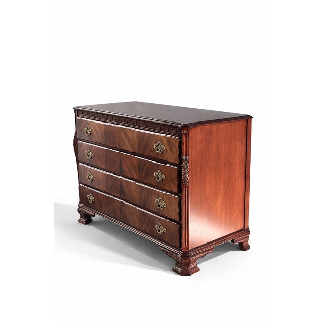 An elegant 1940s antique mahogany chest of drawers, finely crafted with striking book matched flame mahogany veneer and...
