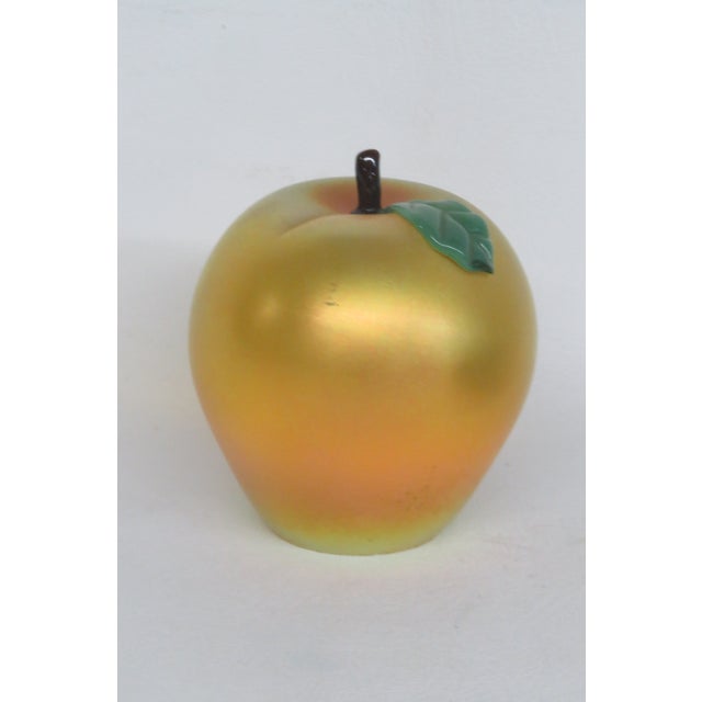 This brilliant Apple Paperweight is made of art glass. This beautiful sculptural apple presents an iridescent gold color...