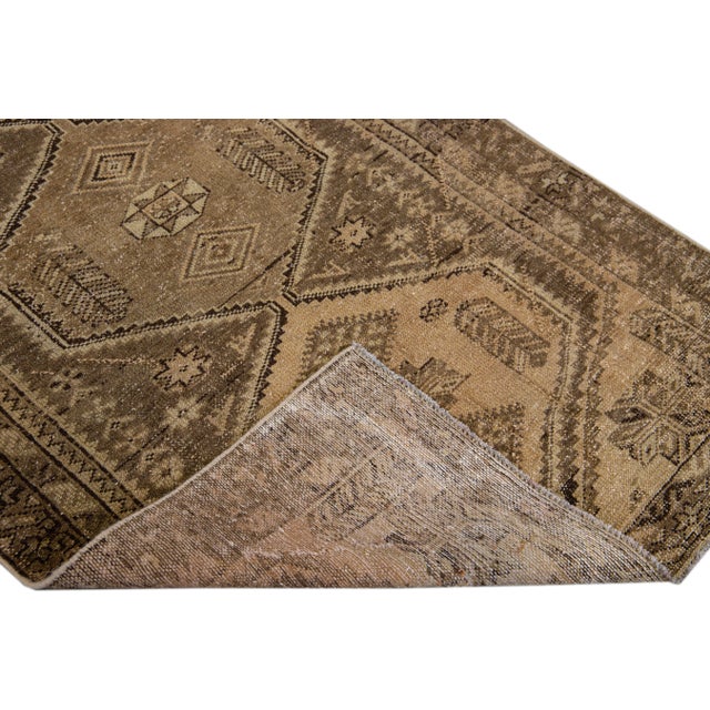 Beautiful Vintage Geometric hand-knotted wool rug with a brown field. This rug has beige accents all-over a geometric...