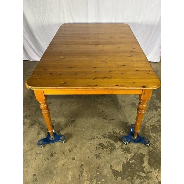 A large extendable pine farmhouse table featuring turned legs. The table is finished in a warm wood tone and can be...