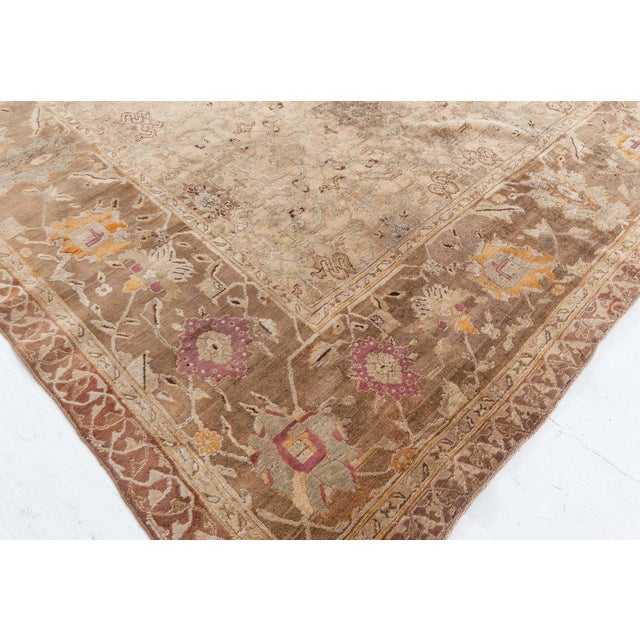 The antique Indian Agra rug dating back to circa 1900. Its main field displays a faded grid of palmettes and vines. The...