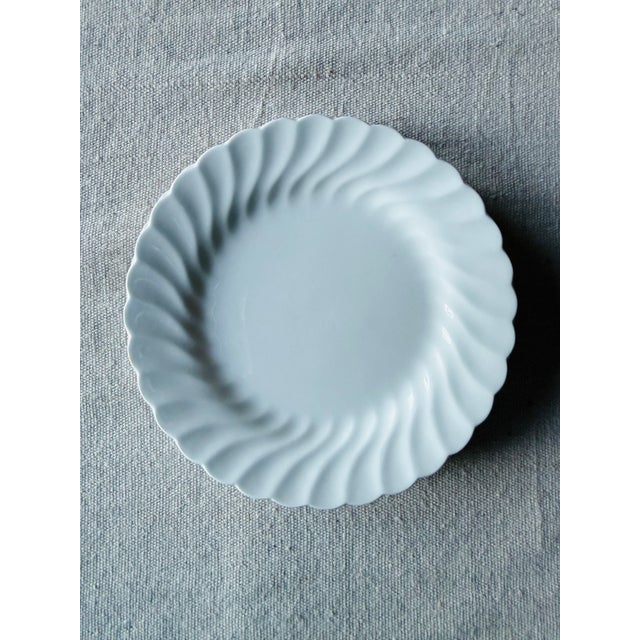 Lovely set of five plates , made in England, presented in all white with a slightly fluted edge that swirls around the rim...