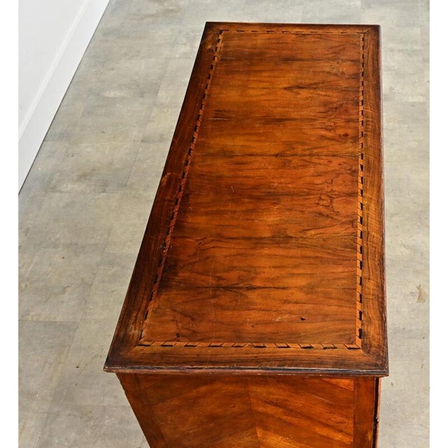 This Italian chest of drawers from the 19th century, in its wide, rectilinear proportions becomes a showcase for the...