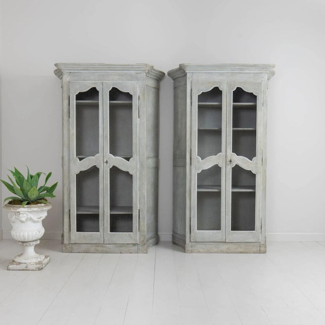 A French, blue-gray painted two-door cabinet (two available) from the 19th century with wire mesh door fronts and canted...