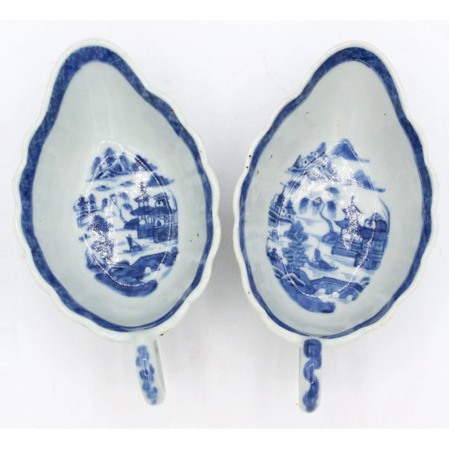 Circa 1830 near pair of Blue Canton sauce boats, Chinese. Leaf shaped with undulating borders & loop handles. Some kiln...
